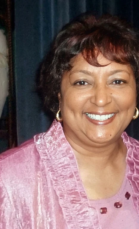 Dr. Winifred Frelow, founder of Winners For Life, smiling in a pink jacket